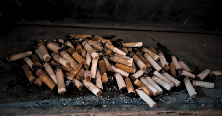 Cigarette butts on a bathroom window pane symbolizing repeated impulsive behaviour in trading and fat loss.
